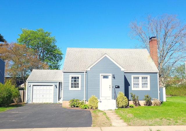 view of front of property with a chimney, aphalt driveway, a garage, roof with shingles, and a front lawn