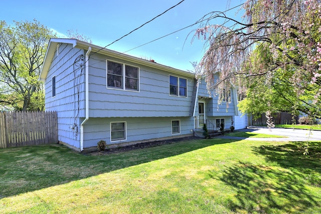 view of front of property with a garage, fence, and a front yard