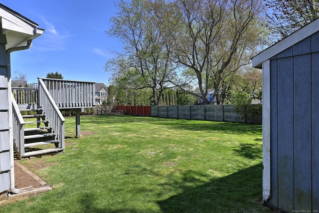 view of yard with a fenced backyard, stairs, and a deck