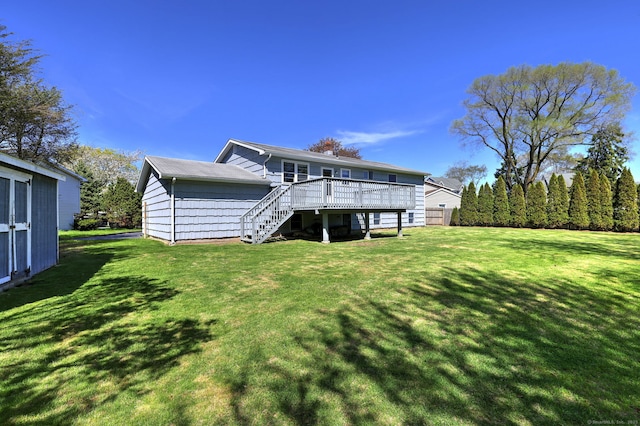 rear view of property with stairway, a lawn, and a wooden deck