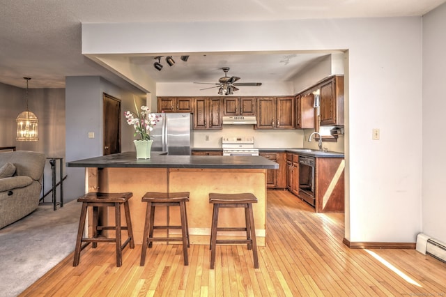 kitchen with freestanding refrigerator, white range with electric cooktop, under cabinet range hood, light wood finished floors, and dishwasher
