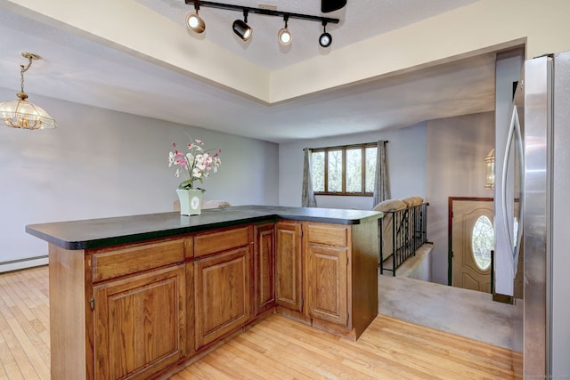 bar featuring freestanding refrigerator, hanging light fixtures, light wood finished floors, and a baseboard radiator