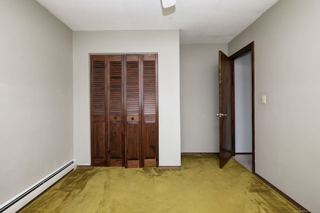 unfurnished bedroom with a closet, ceiling fan, baseboard heating, and carpet flooring