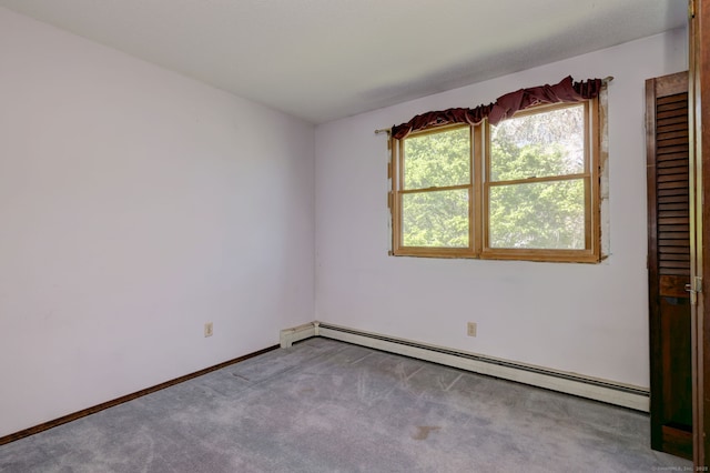spare room featuring carpet floors, baseboards, and a baseboard radiator