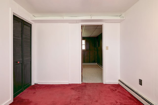carpeted spare room with baseboards and a baseboard heating unit