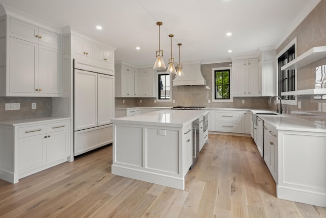 317 Park St, New Canaan, CT 06840 - kitchen featuring custom range hood, built in appliances, ornamental molding, decorative backsplash, and a center island