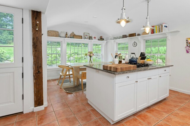 112 Easton Rd, Westport, CT 06880 - kitchen featuring light tile patterned floors, healthy amount of natural light, white cabinets, lofted ceiling, and pendant lighting