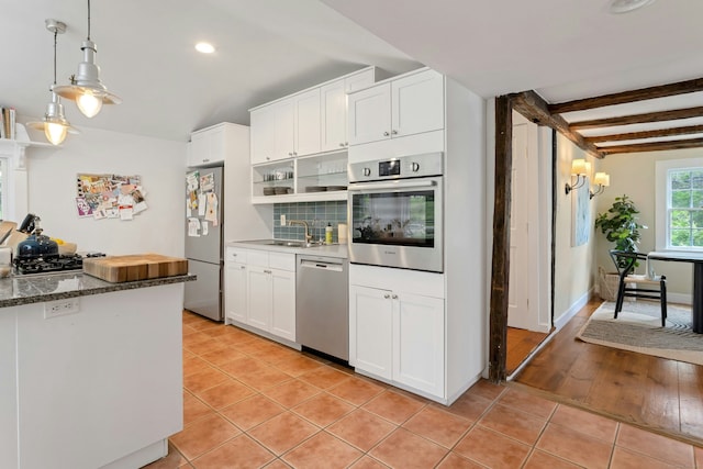 112 Easton Rd, Westport, CT 06880 - kitchen with stainless steel appliances, light tile patterned floors, white cabinets, pendant lighting, and recessed lighting