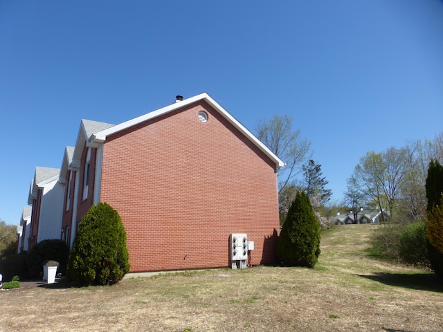 view of side of property with a yard and brick siding