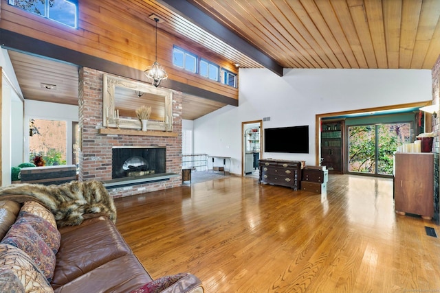 living area featuring wood finished floors, a healthy amount of sunlight, and high vaulted ceiling