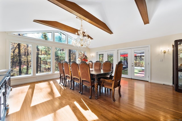 dining room with a chandelier, french doors, vaulted ceiling with beams, a healthy amount of sunlight, and wood finished floors