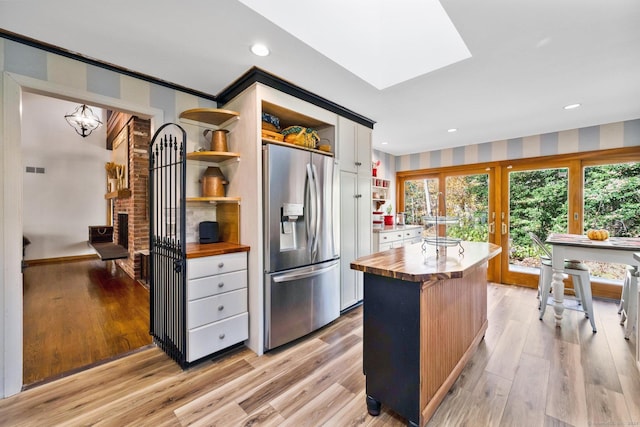 kitchen featuring wooden counters, stainless steel refrigerator with ice dispenser, open shelves, white cabinets, and light wood-style floors