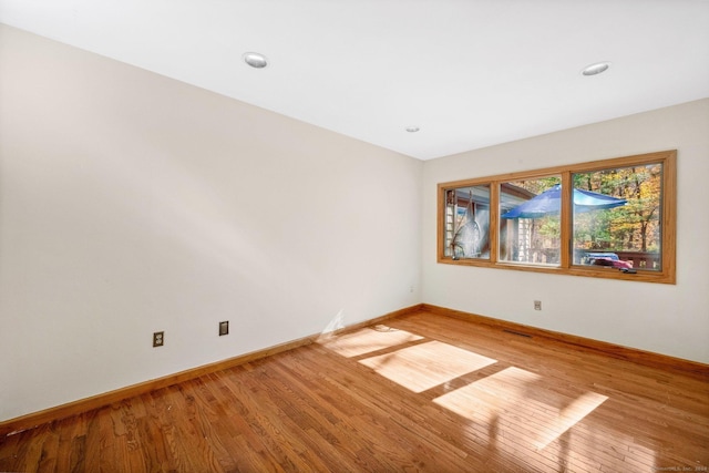 spare room featuring baseboards, recessed lighting, visible vents, and light wood-type flooring