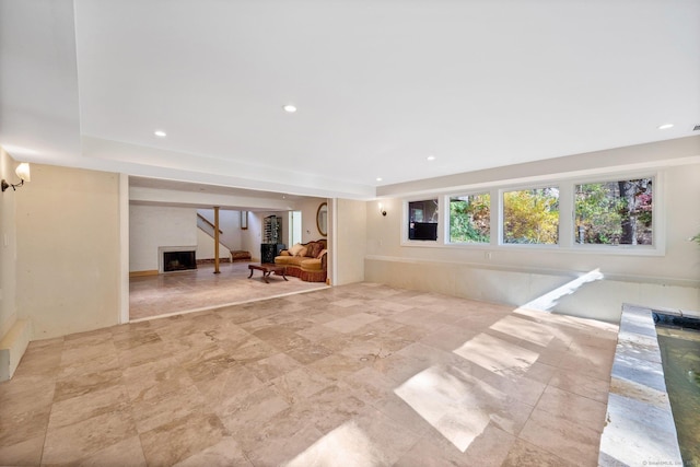 unfurnished living room featuring recessed lighting, a raised ceiling, and a fireplace