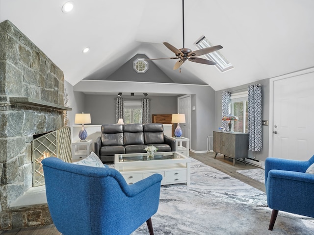 living room featuring visible vents, wood finished floors, a fireplace, a ceiling fan, and vaulted ceiling