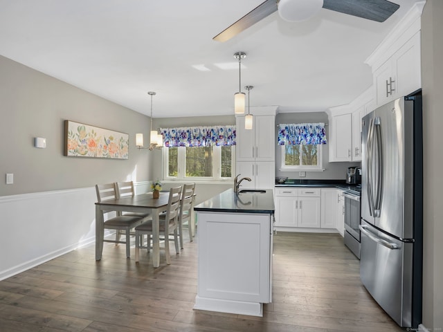 kitchen featuring appliances with stainless steel finishes, white cabinets, dark countertops, and a healthy amount of sunlight