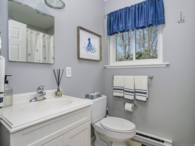 bathroom featuring toilet, a baseboard heating unit, and vanity