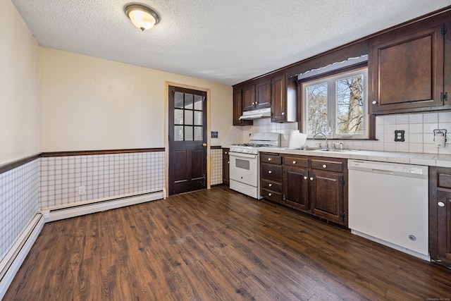 kitchen with white appliances, dark brown cabinets, under cabinet range hood, and tile countertops