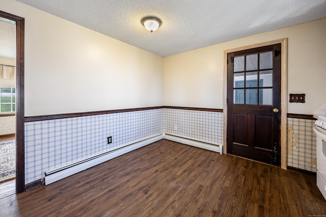 empty room with a textured ceiling, wood finished floors, and a wainscoted wall