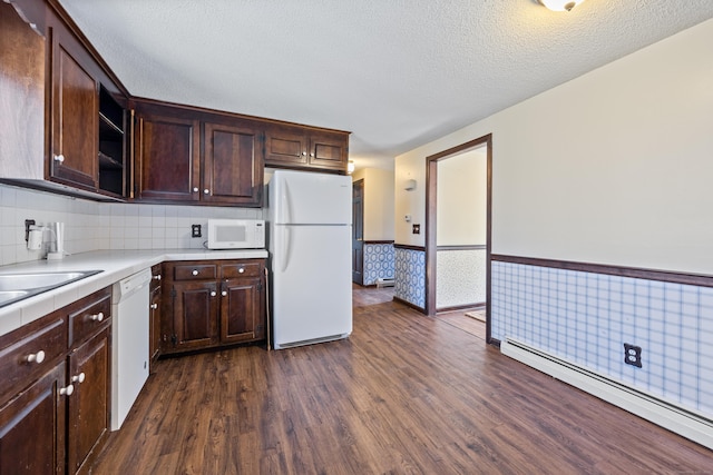 kitchen with white appliances, dark brown cabinetry, a baseboard heating unit, and dark wood finished floors