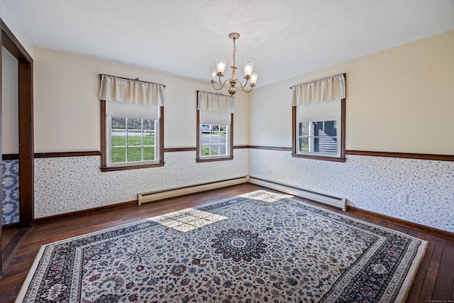 unfurnished room featuring an inviting chandelier, wainscoting, hardwood / wood-style floors, baseboards, and wallpapered walls