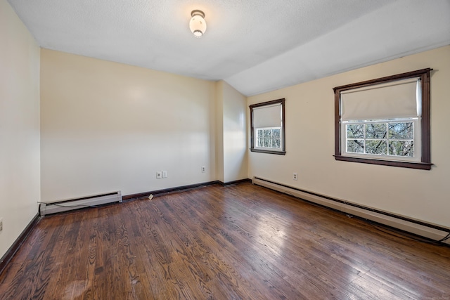spare room with a baseboard radiator, wood finished floors, and vaulted ceiling