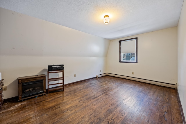 bonus room with baseboards, a textured ceiling, a baseboard heating unit, and wood finished floors