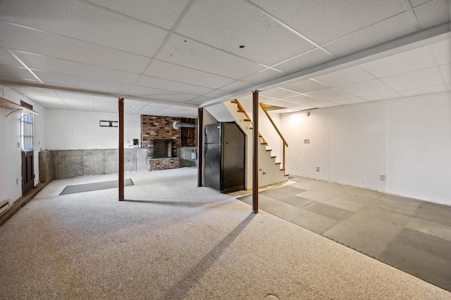below grade area featuring carpet floors, a paneled ceiling, stairs, and a fireplace