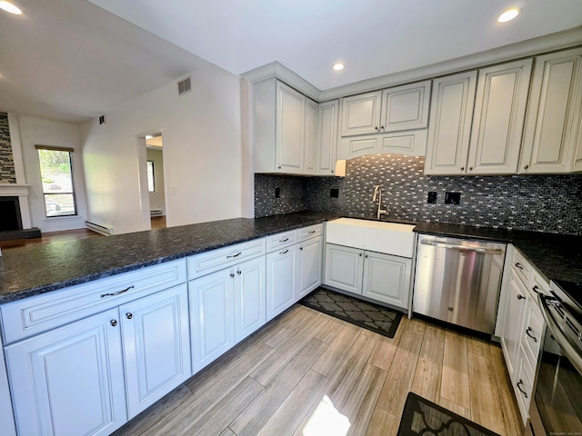 664C Heritage Vlg, Southbury, CT 06488 - kitchen with dishwasher, a peninsula, a baseboard heating unit, decorative backsplash, and recessed lighting