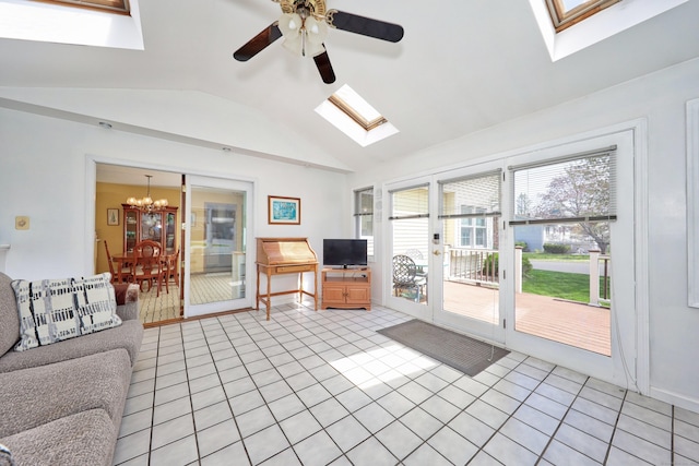 living room featuring light tile patterned floors, lofted ceiling with skylight, and ceiling fan with notable chandelier