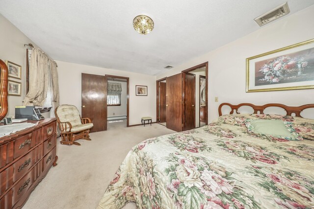 bedroom featuring light colored carpet, visible vents, and baseboard heating