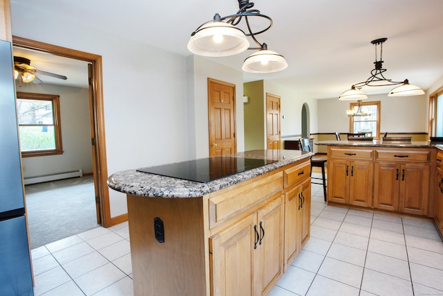 kitchen with a healthy amount of sunlight, a baseboard heating unit, ceiling fan with notable chandelier, and a kitchen island
