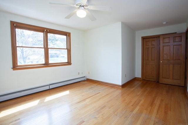 unfurnished room with light wood finished floors, a ceiling fan, baseboards, and a baseboard radiator