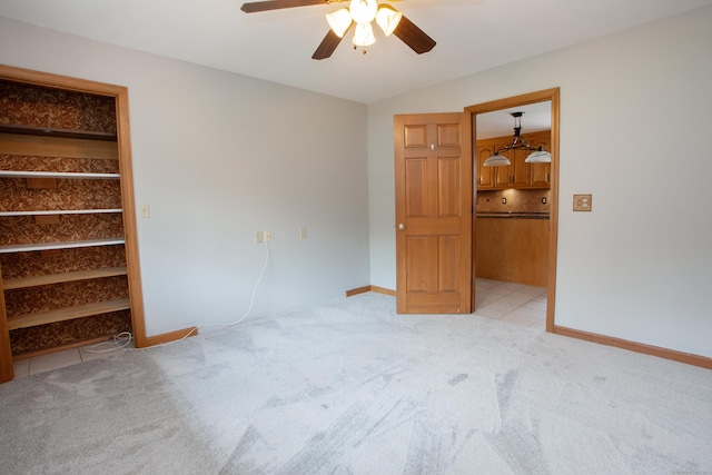 unfurnished bedroom featuring ceiling fan, light carpet, and baseboards