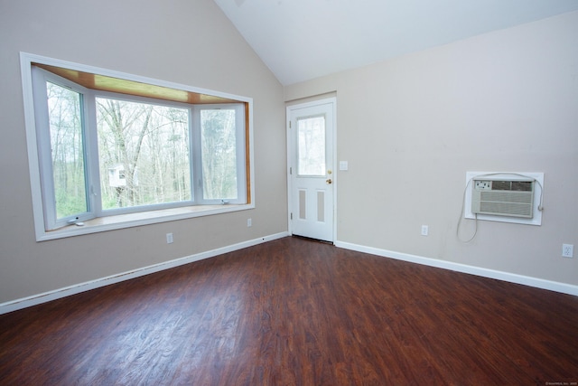 spare room featuring a wall mounted air conditioner, a healthy amount of sunlight, and dark wood-style flooring