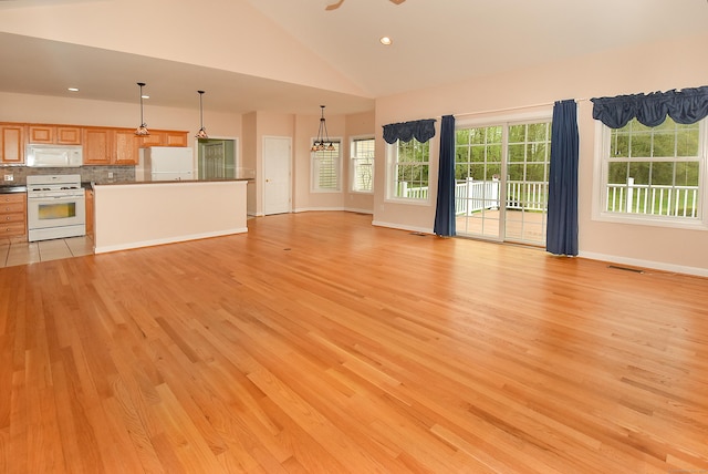 unfurnished living room featuring visible vents, baseboards, high vaulted ceiling, light wood-style floors, and recessed lighting