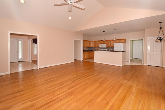 unfurnished living room with baseboards, ceiling fan, high vaulted ceiling, recessed lighting, and light wood-type flooring