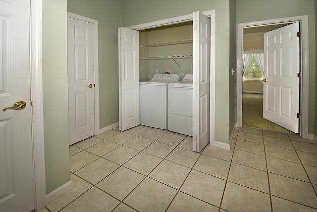 laundry room with independent washer and dryer, laundry area, baseboards, and light tile patterned floors