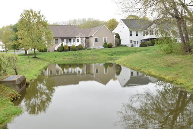 rear view of house with a lawn and a water view