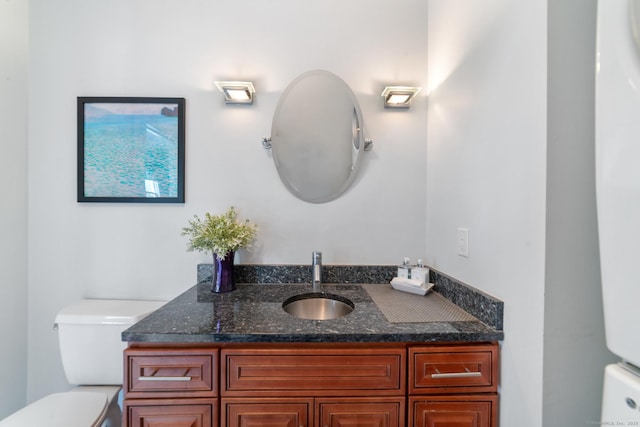 half bathroom featuring vanity and toilet