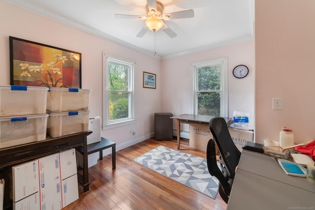 office area with crown molding, a ceiling fan, a baseboard heating unit, and wood finished floors