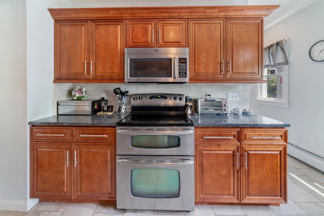 kitchen with dark stone countertops, appliances with stainless steel finishes, a toaster, and tasteful backsplash
