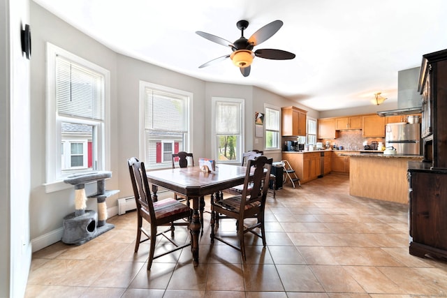 dining space featuring light tile patterned floors, baseboards, and ceiling fan