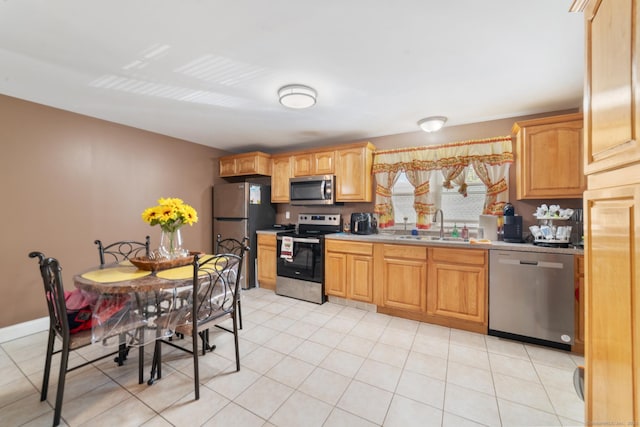 kitchen featuring light countertops, light tile patterned floors, appliances with stainless steel finishes, and a sink
