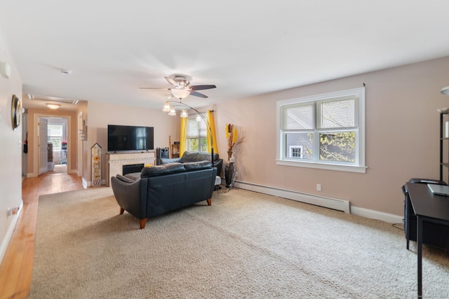 living area featuring ceiling fan, a baseboard heating unit, light carpet, and baseboards