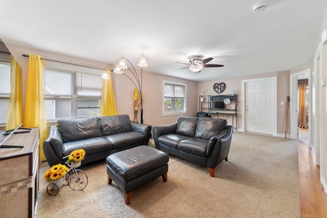 living area with baseboards and a ceiling fan