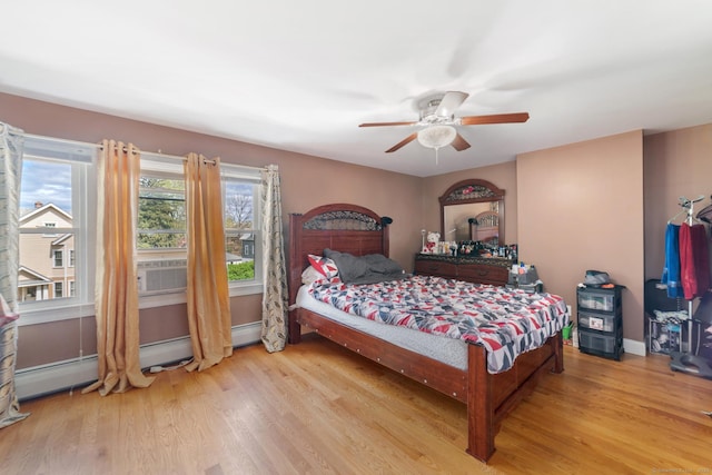 bedroom with baseboards, ceiling fan, baseboard heating, and wood finished floors