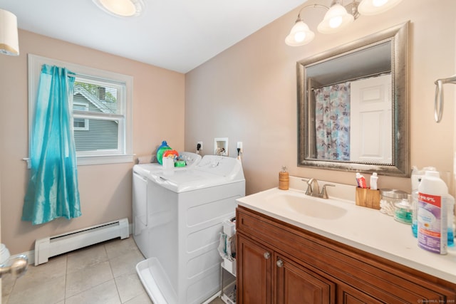 laundry area featuring laundry area, washing machine and clothes dryer, a sink, a baseboard heating unit, and light tile patterned flooring