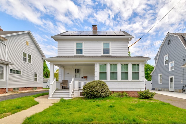 409 Third Ave, West Haven, CT 06516 - american foursquare style home featuring a porch, a chimney, a front lawn, and roof mounted solar panels