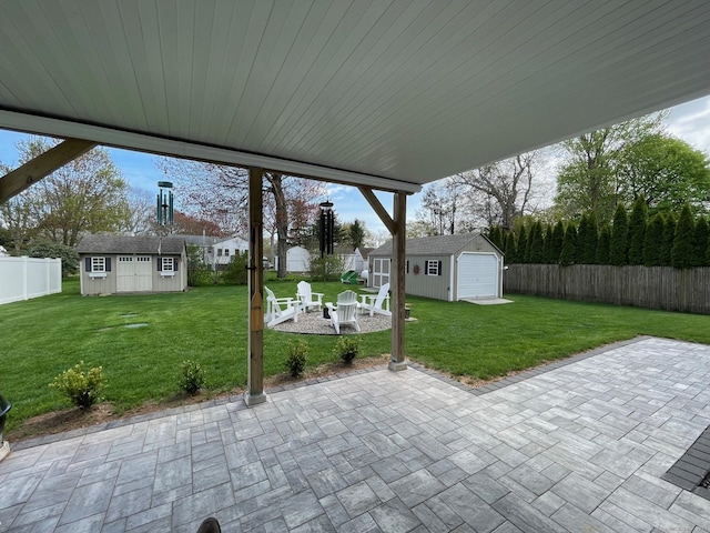 16 Catherine Dr, Wolcott, CT 06716 - view of patio featuring an outdoor structure, a fenced backyard, an outdoor fire pit, and a storage unit